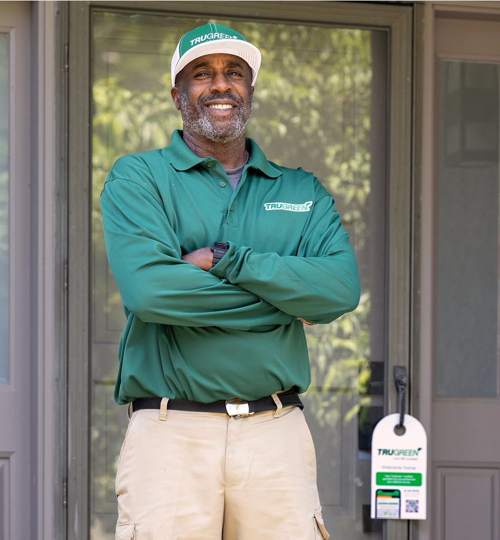 A friendly TruGreen customer service expert wearing a headset and smiling, ready to assist.
